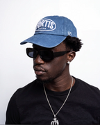 Washed navy ENZURA cap, angled view showing the six-panel crown and curved brim