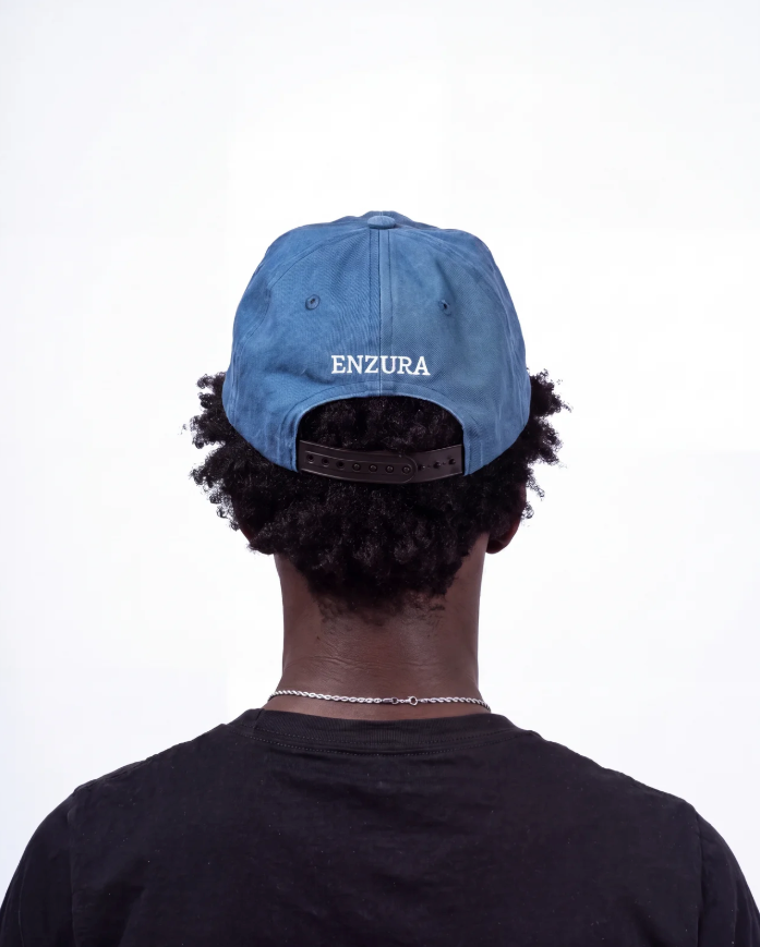 Washed navy ENZURA cap, back view showing the ENZURA wordmark above the snapback closure